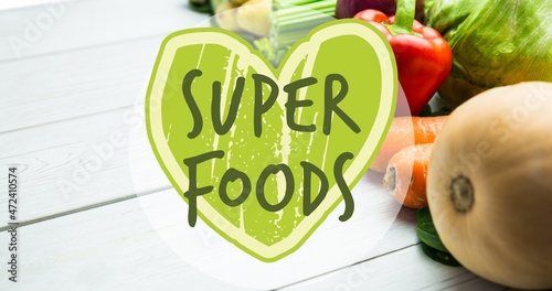 Super foods on green heart shape symbol over fresh vegetables
