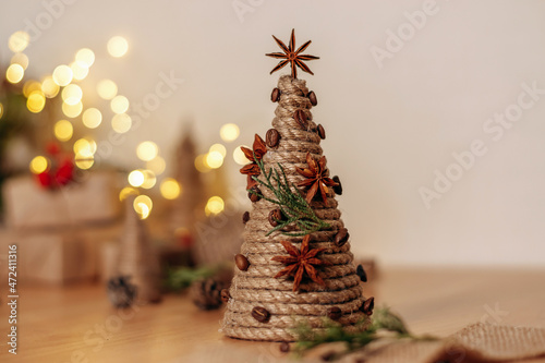 A creative handmade Christmas tree made of a cardboard cone, wrapped with rope and decorated with coffee beans and a anise.Christmas,New Year and eco-friendly concept.Selective focus,copy space. photo