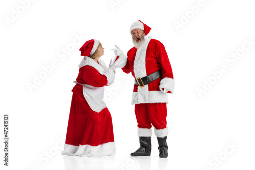 Angry elder man, Santa Claus shouting at woman, missis Claus isolated on white background.