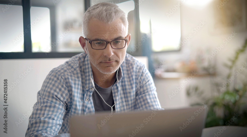 man telecommuting on his laptop at home man telecommuting on his laptop at home