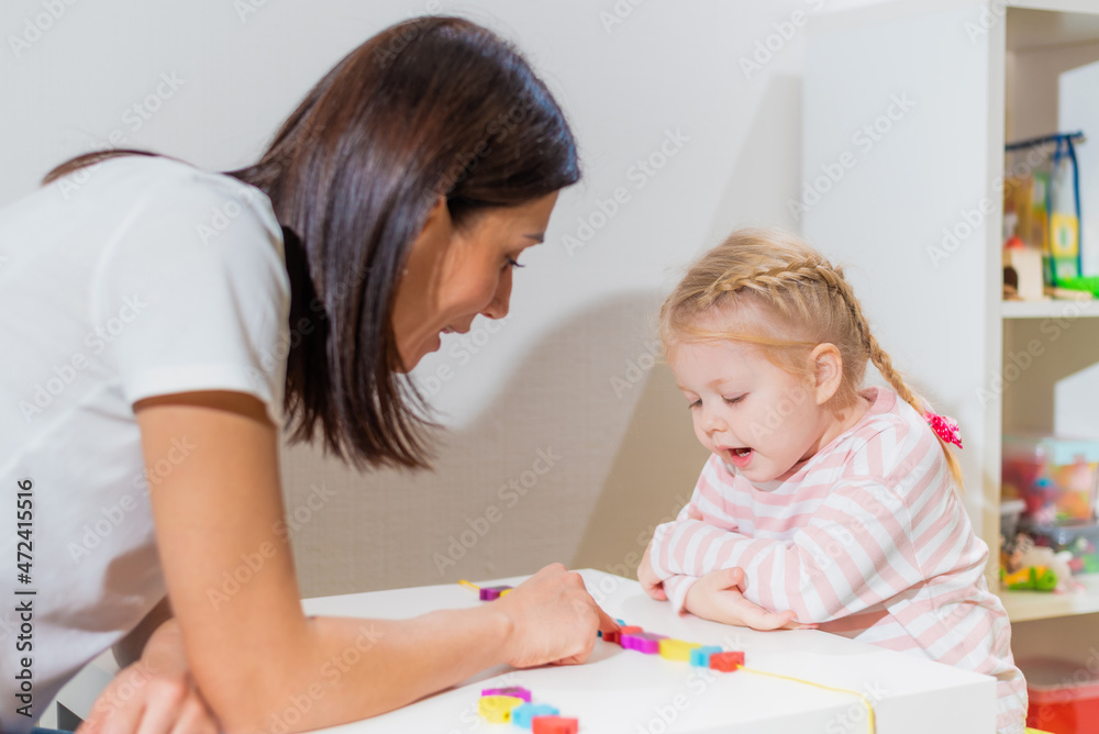 Woman speech therapist teaches a girl the correct pronunciation and literate speech Woman speech therapist teaches a girl the correct pronunciation and literate speech