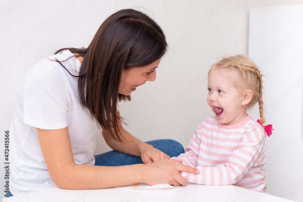 Woman speech therapist helps cute girl to learn correct pronunciation and literate speech Woman speech therapist helps cute girl to learn correct pronunciation and literate speech