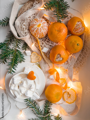 Christmas still life with tangerines and marshmallows in cup of latte coffee