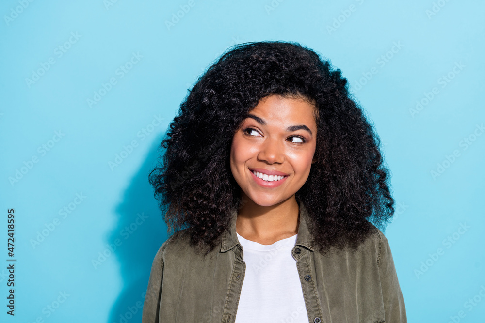 Photo of young cheerful lovely african girl dreamy curious look empty space isolated over blue color background Photo of young cheerful lovely african girl dreamy curious look empty space isolated over blue color background