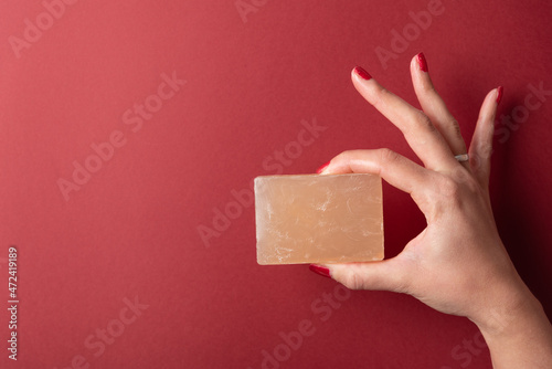 Woman hand holding soap with two fingers