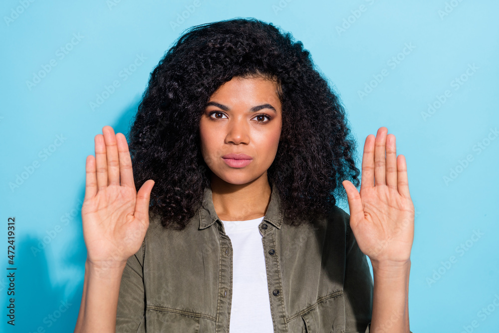 Photo of young african woman show palms stop gender discrimination isolated over blue color background Photo of young african woman show palms stop gender discrimination isolated over blue color background
