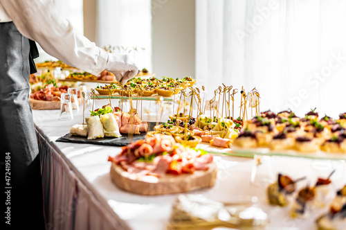 waiter prepare food for a buffet table in a restaurant photo