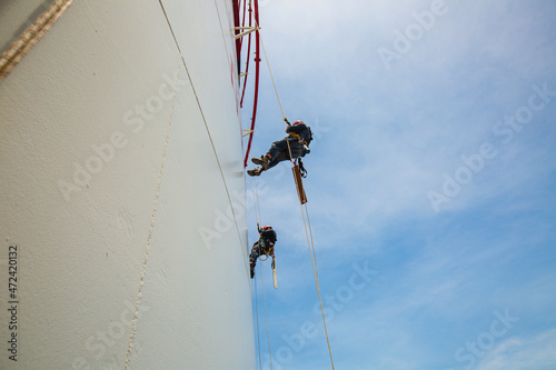 Male two workers down height tank rope access inspection of thickness shell plate storage tank gas propane.
