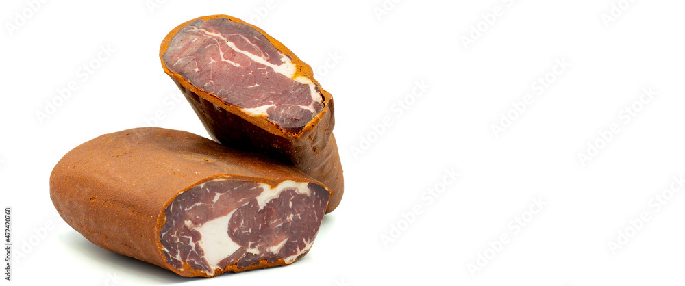 Obraz premium Turkish pastrami on a white background. Bacon made from veal. Turkish bacon, pastrami (Kayseri pastirma). Empty space for text. copy space