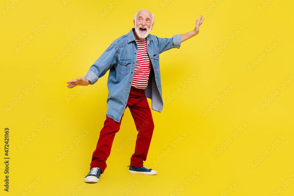 Fototapeta premium Full length body size view of attractive cheerful grey-haired man dancing having fun rest isolated over bright yellow color background