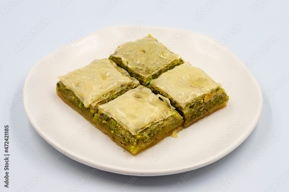 Pistachio baklava on a white background. Turkish style pistachio baklava presentation and service. Horizontal view. close up Pistachio baklava on a white background. Turkish style pistachio baklava presentation and service. Horizontal view. close up