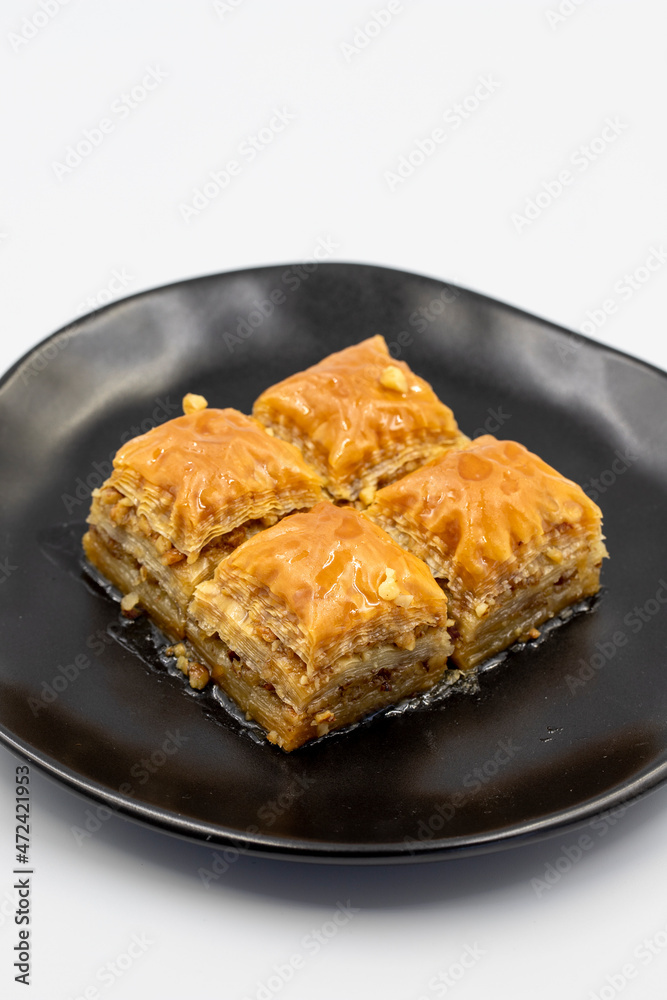 Walnuts baklava isolated on a white background. Turkish style walnut baklava presentation and service. Vertical view. close up Walnuts baklava isolated on a white background. Turkish style walnut baklava presentation and service. Vertical view. close up