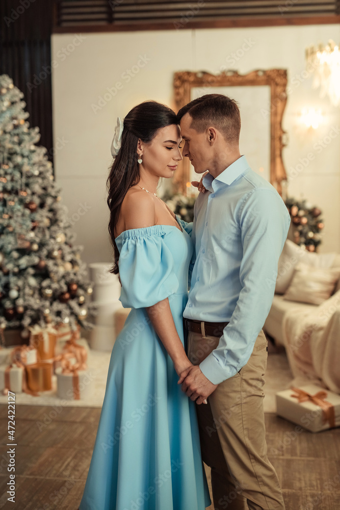 happy couple husband and wife at home in living room near christmas tree happy couple husband and wife at home in living room near christmas tree