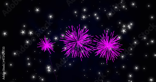 Image of pink christmas and new year fireworks exploding in starry night sky