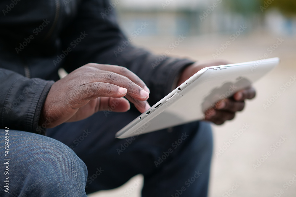 African american man uses tablet computer. Black mans hands holds a tablet pc