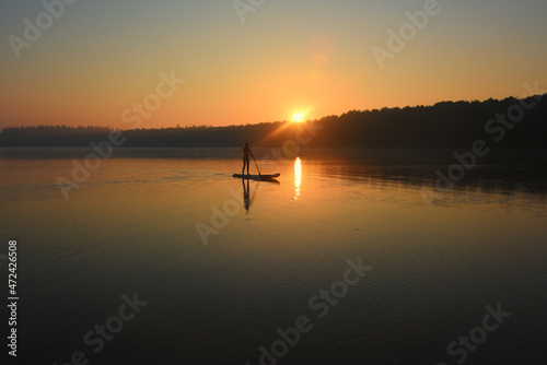 paddleboard on lake at sunrise