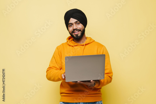 Canvas Print Bearded south asian man wearing turban using laptop