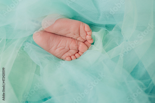 Baby's feet under a green blanket