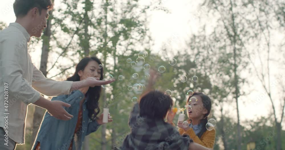 Happy young family blowing bubbles in park,4K Happy young family blowing bubbles in park,4K