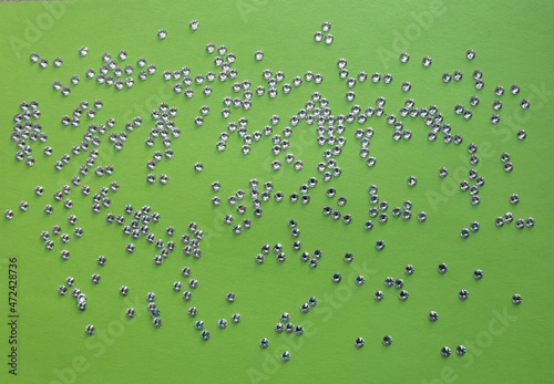 rhinestones on a green background, top photo. design for text
