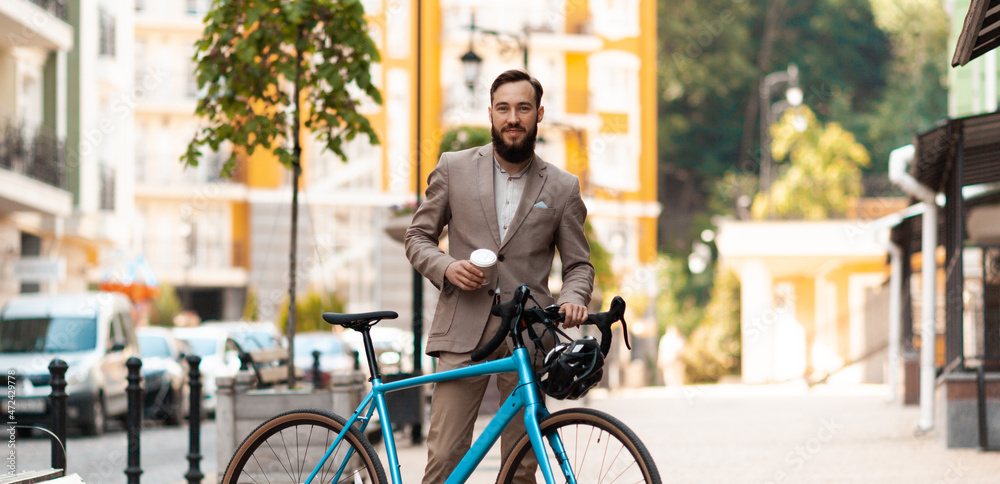Young businessman on the way to work by bike. Ecological urban transport.
