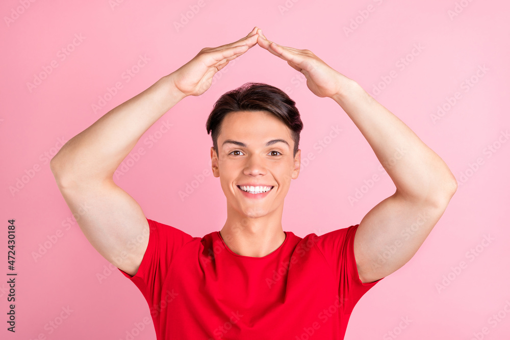 Photo of young guy happy positive smile hold hands home protection buy real estate isolated over pink color background Photo of young guy happy positive smile hold hands home protection buy real estate isolated over pink color background