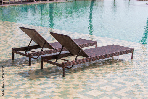 Deck chairs in the swimming pool at a tropical resort near sea in Burma, Myanmar