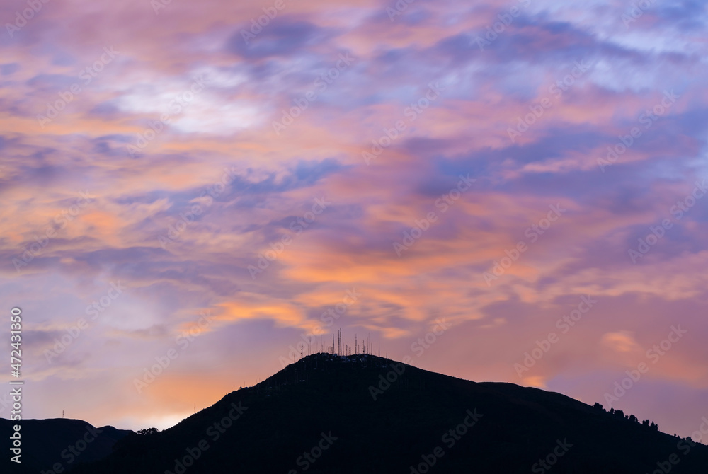 Pichincha volcano silhouette at sunset, Quito, Pichincha province, Ecuador. Focus on antenna peak.