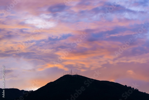 Pichincha volcano silhouette at sunset, Quito, Pichincha province, Ecuador. Focus on antenna peak.