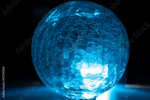 Esefera de cristal rajada con luz azul photo