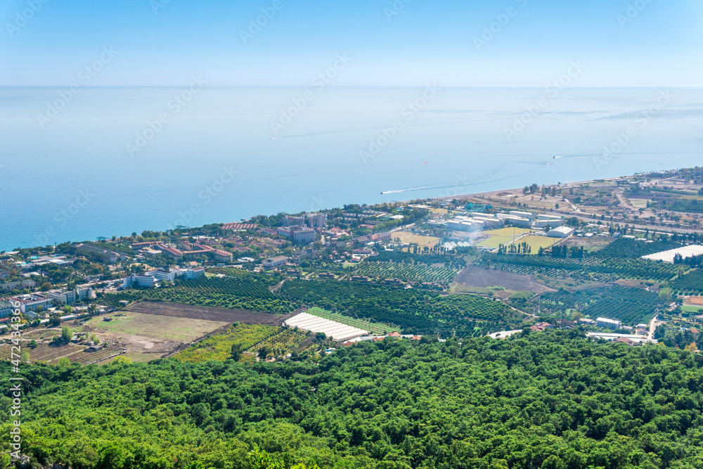 top view of Mediterranean coastal resort village with gardens and hotels in Camyuva, Turkey