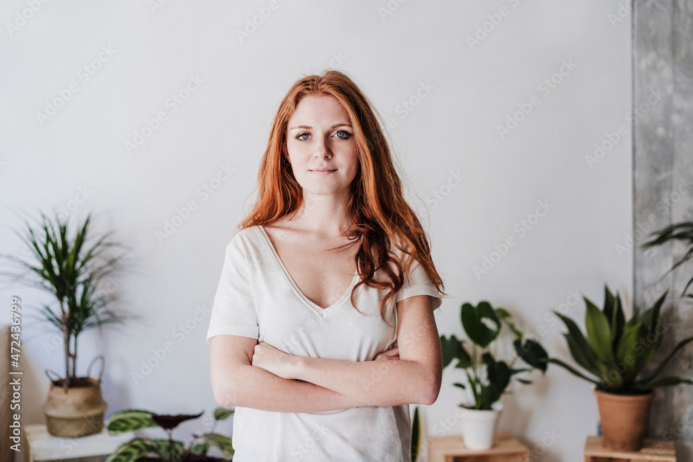 Beautiful woman with arms crossed standing in living room Beautiful woman with arms crossed standing in living room