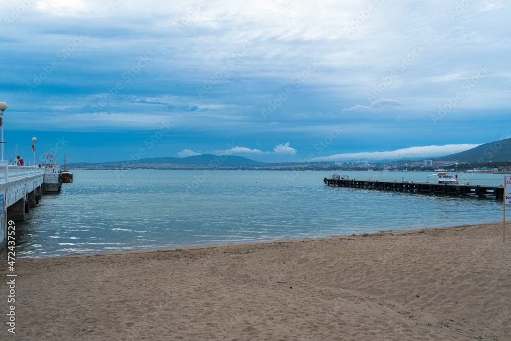 Gelendzhik Russia city, black sea and embankment with blue sky on the beach foreground. Gelendzhik Russia city, black sea and embankment with blue sky on the beach foreground.