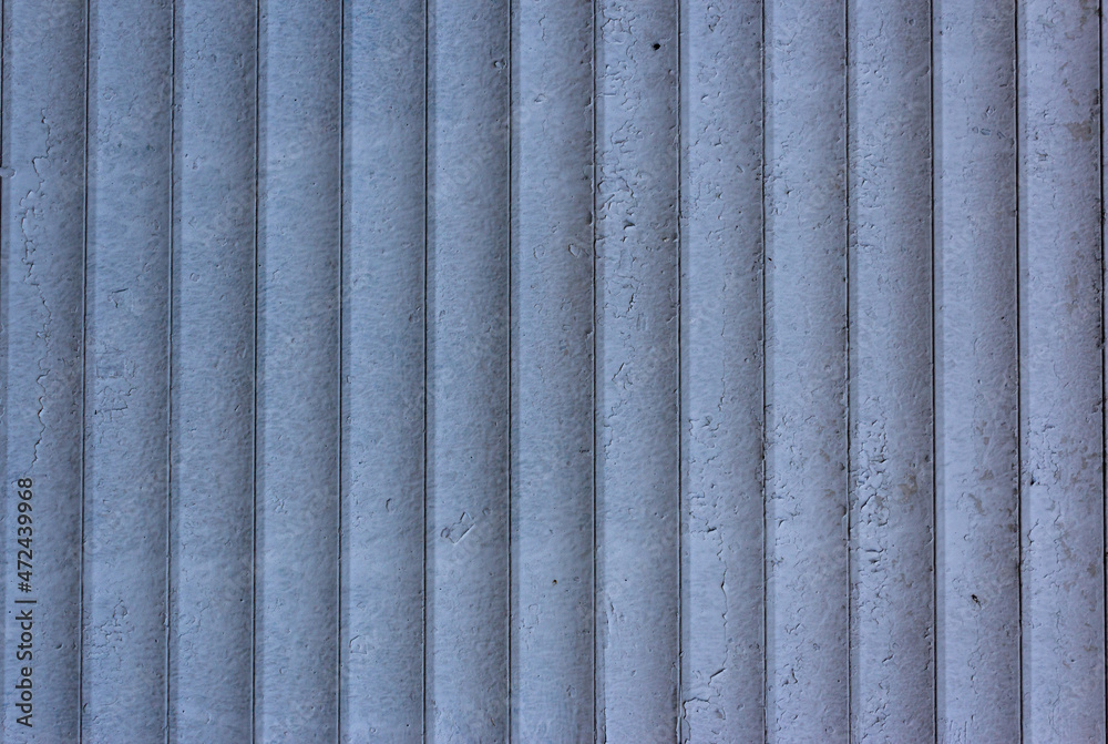 Background of blue vertical metal strips with peeling paint. Roller blinds and garage gates. Closed metal shutter casements. Protecting windows and doors from intruders Background of blue vertical metal strips with peeling paint. Roller blinds and garage gates. Closed metal shutter casements. Protecting windows and doors from intruders