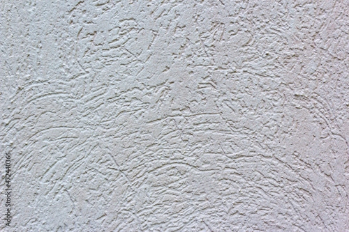 Decorative white wall plaster pattern stylized in bark beetle texture. The white texture of the surface of the wall covered with decorative plaster of the woodworm type, close-up abstract background