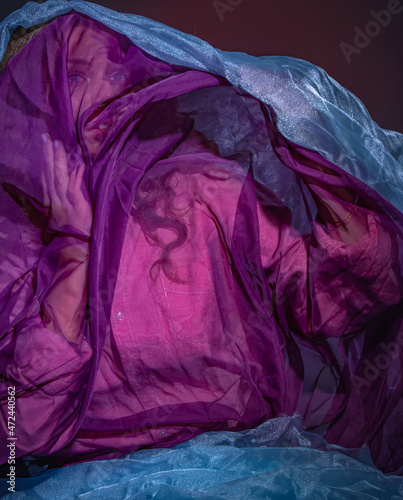 A girl covered with a purple transparent cloth