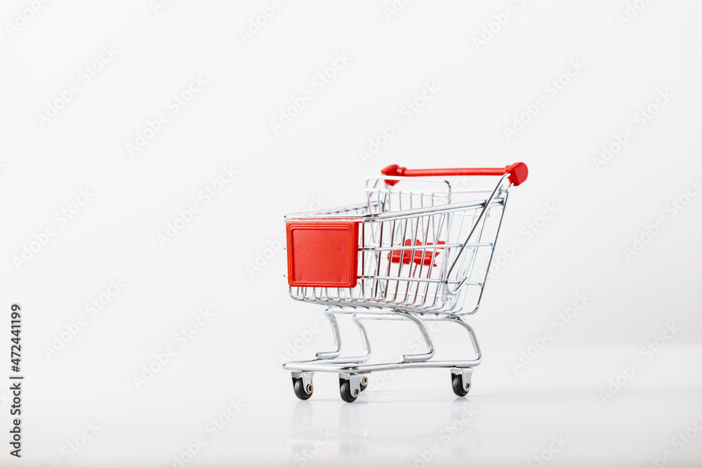 Metallic shopping cart trolley on light gray background with copy space