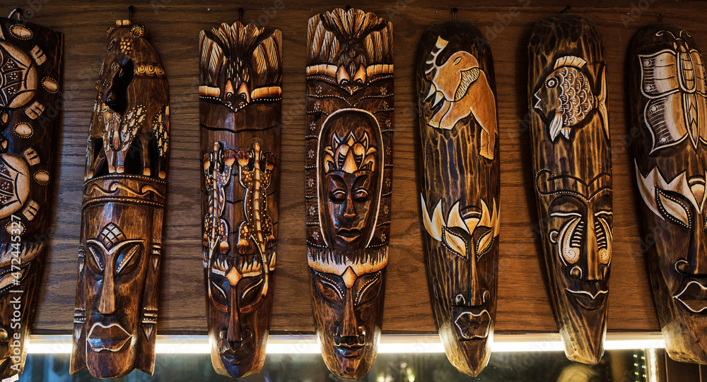 Many authentic African totems on wall at oriental souvenir shop Many authentic African totems on wall at oriental souvenir shop