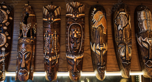 Fotografi Many authentic African totems on wall at oriental souvenir shop