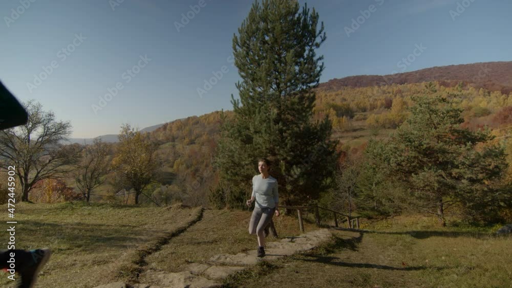 Tired young couple running up the stairs holding maps in their hands. Sunny autumn day. Clear blue sky and mountains on the background Copy space. Tired young couple running up the stairs holding maps in their hands. Sunny autumn day. Clear blue sky and mountains on the background Copy space.