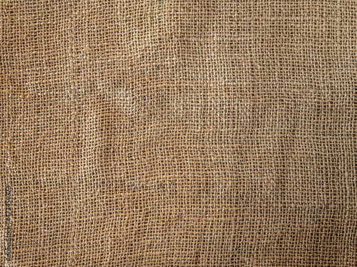 Top view of a rough brown cloth. Fragment of burlap. A neutral rustic background with a characteristic texture.