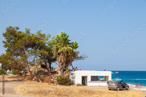 Scenic beachfront location in turkey camyuva with palm trees, car and sand while traveling and vacation