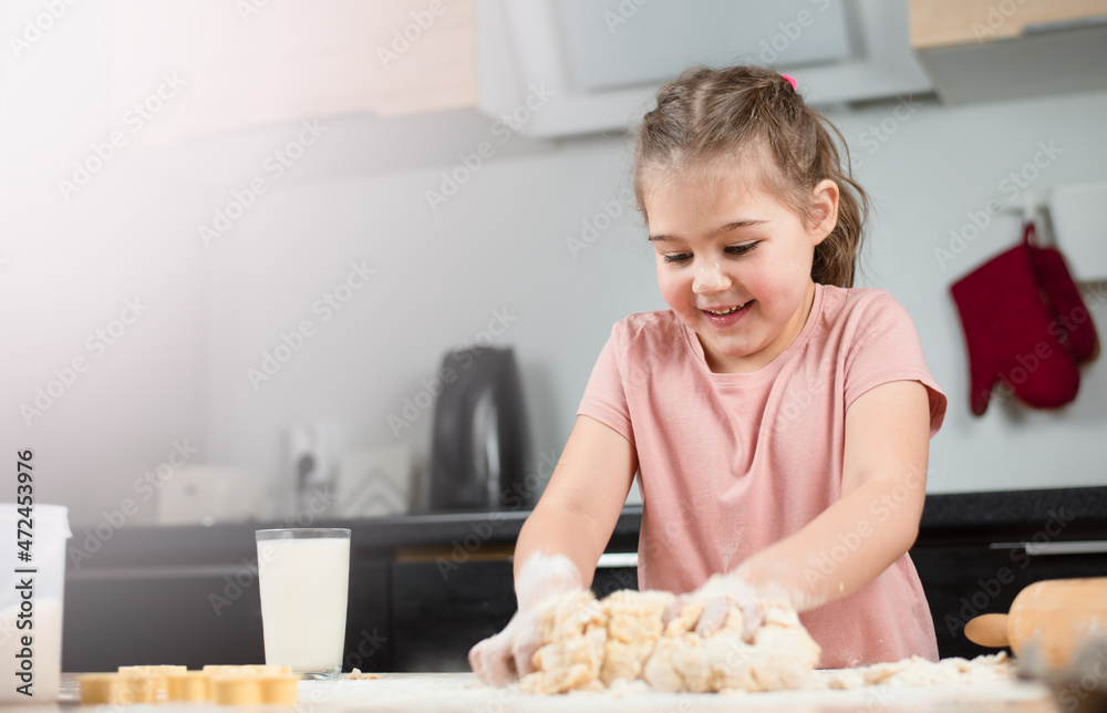 girl kneading cookie dough in the kitchen