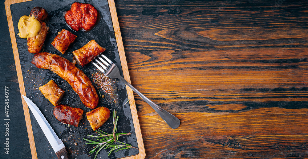 fried sausages with sauces and spices on a stone plate fried sausages with sauces and spices on a stone plate