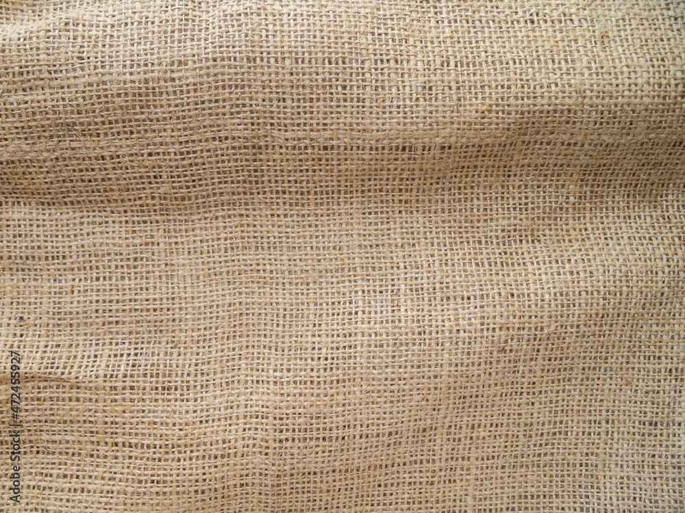 View of a piece of sackcloth. Beige abstract background with fabric texture. View of a piece of sackcloth. Beige abstract background with fabric texture.
