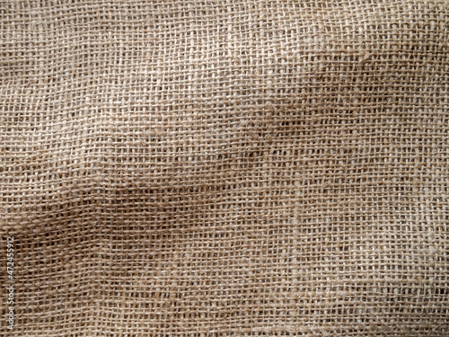 Top view of a rough fabric with folds. A piece of burlap. Rustic background.