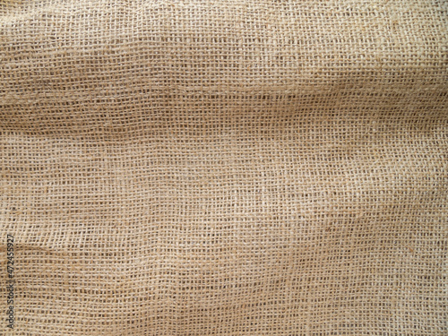 View of a piece of sackcloth. Beige abstract background with fabric texture.