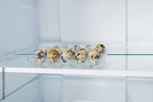 quail eggs on a shelf in an empty refrigerator