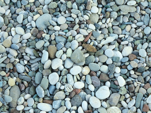 Tela Sea colorful and gray small stones pebbles on a beach