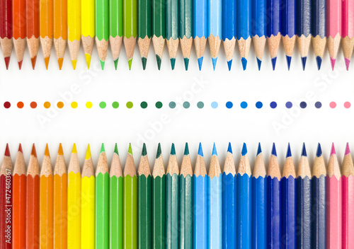 Closeup of colored pencils lined up in a row  and abstract shape on background copy space